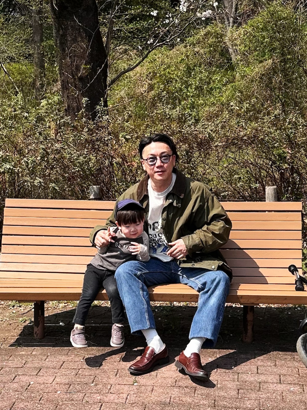 ブルー系のデニムパンツ、ホワイト系のTシャツ/カットソー、グリーン系のジャケット/アウターを着用したメンズの春コーディネートの2枚目の写真