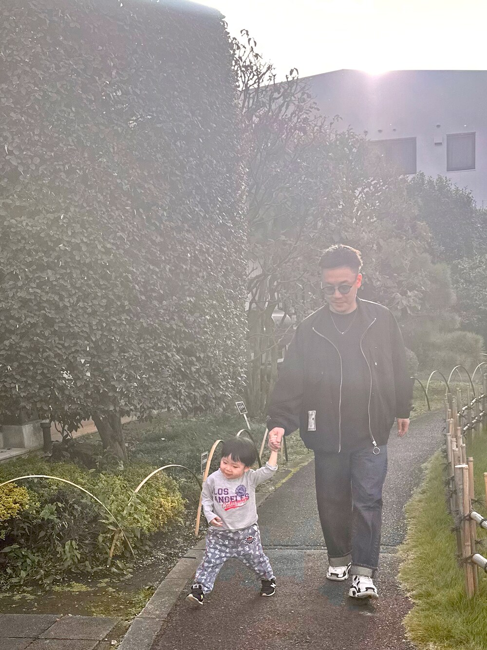 ブラック系のスニーカー、ブラック系のジャケット/アウター、ブルー系のデニムパンツを着用したメンズの秋コーディネートの2枚目の写真