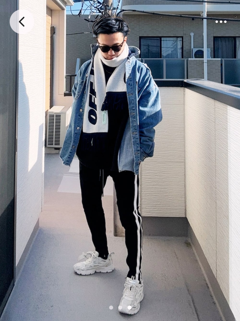 ブラック系のスウェット、ブルー系のデニムジャケット、ブラック系のパンツを着用したメンズの冬コーディネートの2枚目の写真