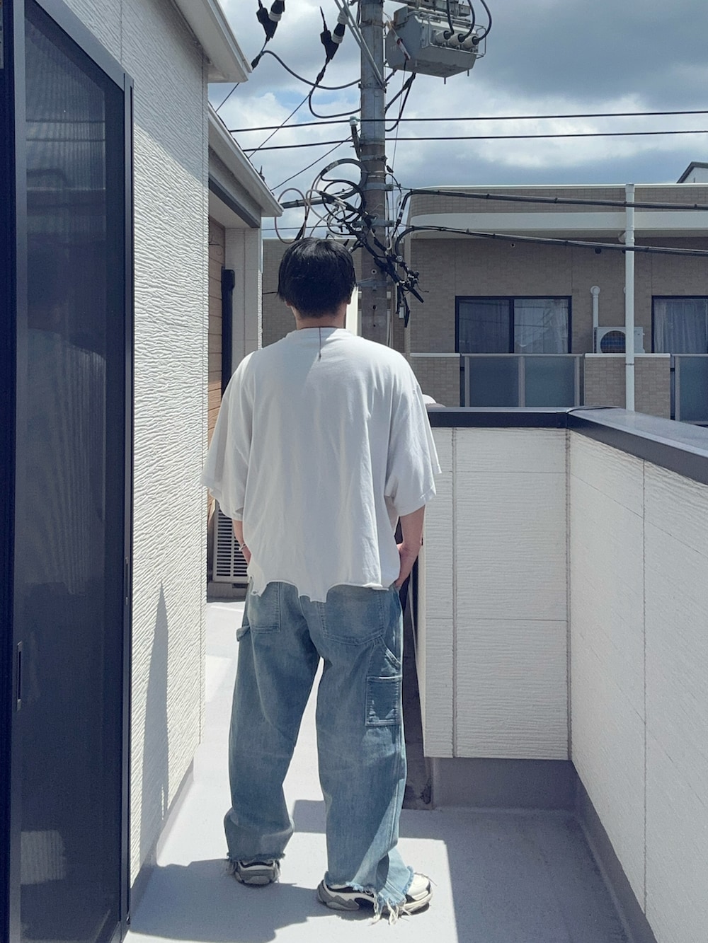 ブルー系のデニムパンツ、ホワイト系のTシャツ/カットソー、ホワイト系のシューズを着用したメンズの夏コーディネートの4枚目の写真