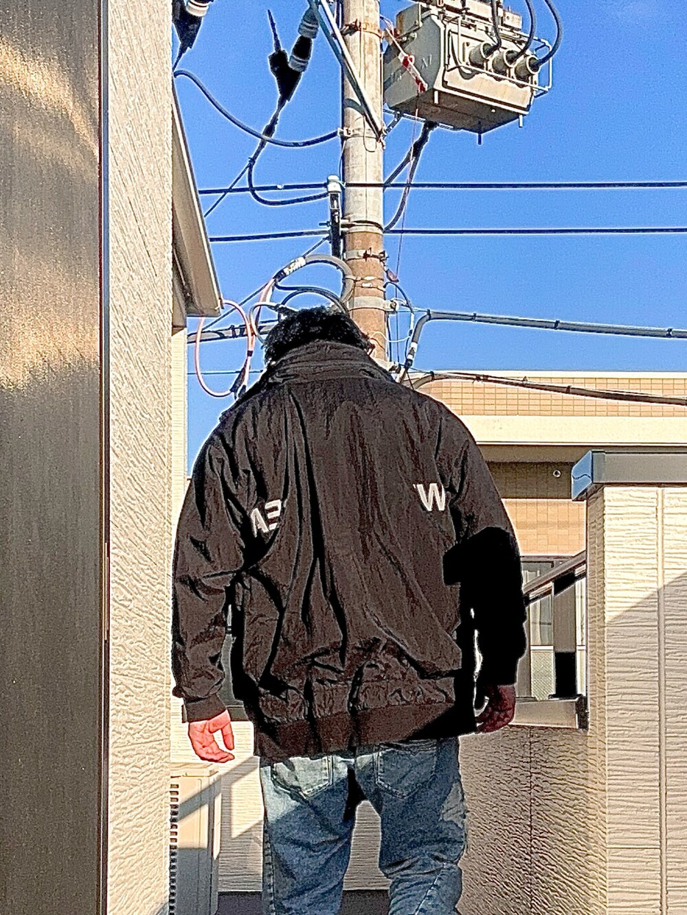 ブルー系のデニムパンツ、ブラック系のTシャツ/カットソー、ブラック系のブルゾンを着用したメンズの冬コーディネートの3枚目の写真
