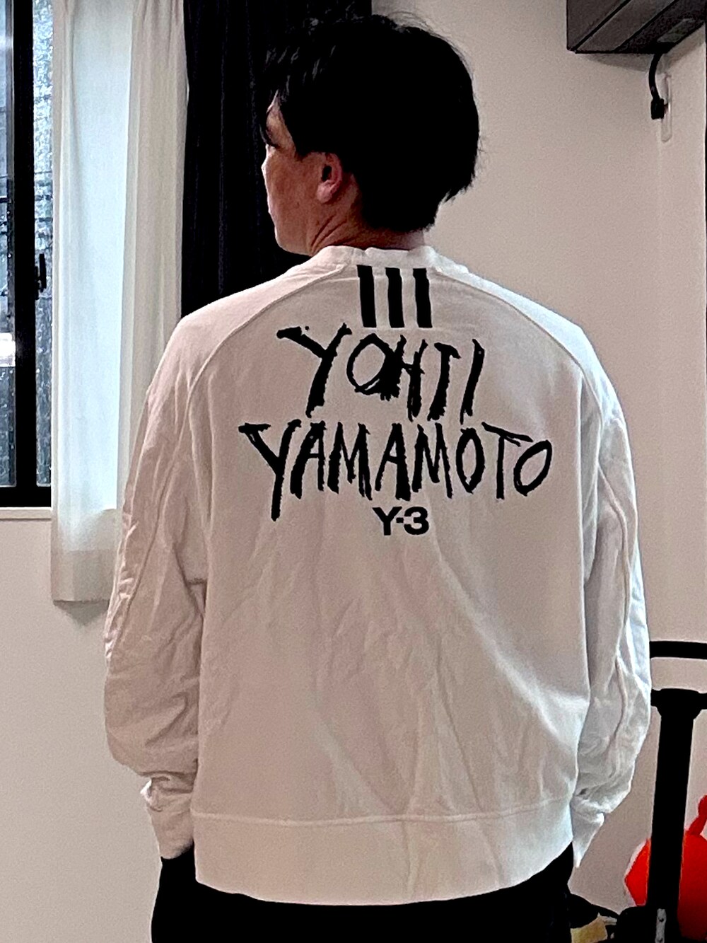 ホワイト系のスウェット、ホワイト系のスニーカー、ブラック系のパンツを着用したメンズの夏コーディネートの2枚目の写真