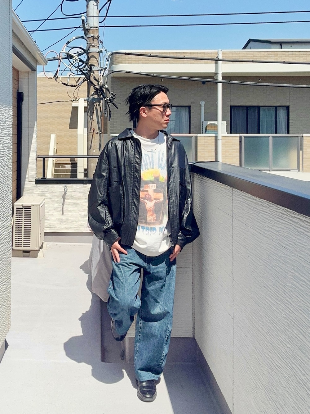ブラック系のブルゾン、ホワイト系のTシャツ/カットソー、ブルー系のデニムパンツを着用したメンズの春コーディネートの3枚目の写真