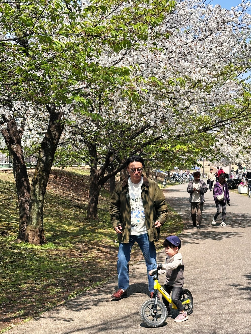 ブルー系のデニムパンツ、ホワイト系のTシャツ/カットソー、グリーン系のジャケット/アウターを着用したメンズの春コーディネートの5枚目の写真