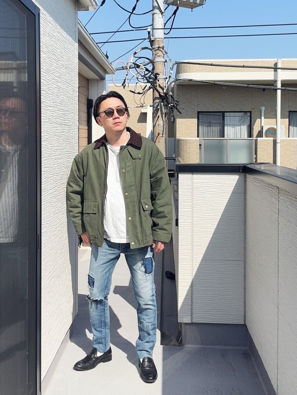 ブラック系のローファー、ホワイト系のTシャツ/カットソー、グリーン系のミリタリージャケットを着用したメンズの春コーディネートの3枚目の写真