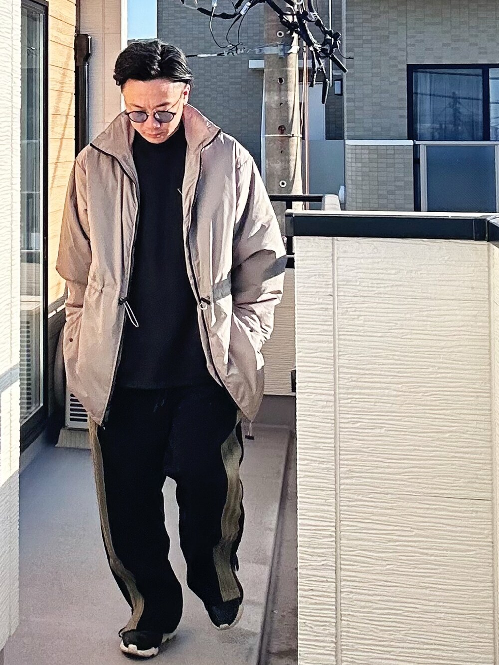 ブラック系のスウェット、ベージュ系のその他アウター、ブラック系のパンツを着用したメンズの冬コーディネートの3枚目の写真