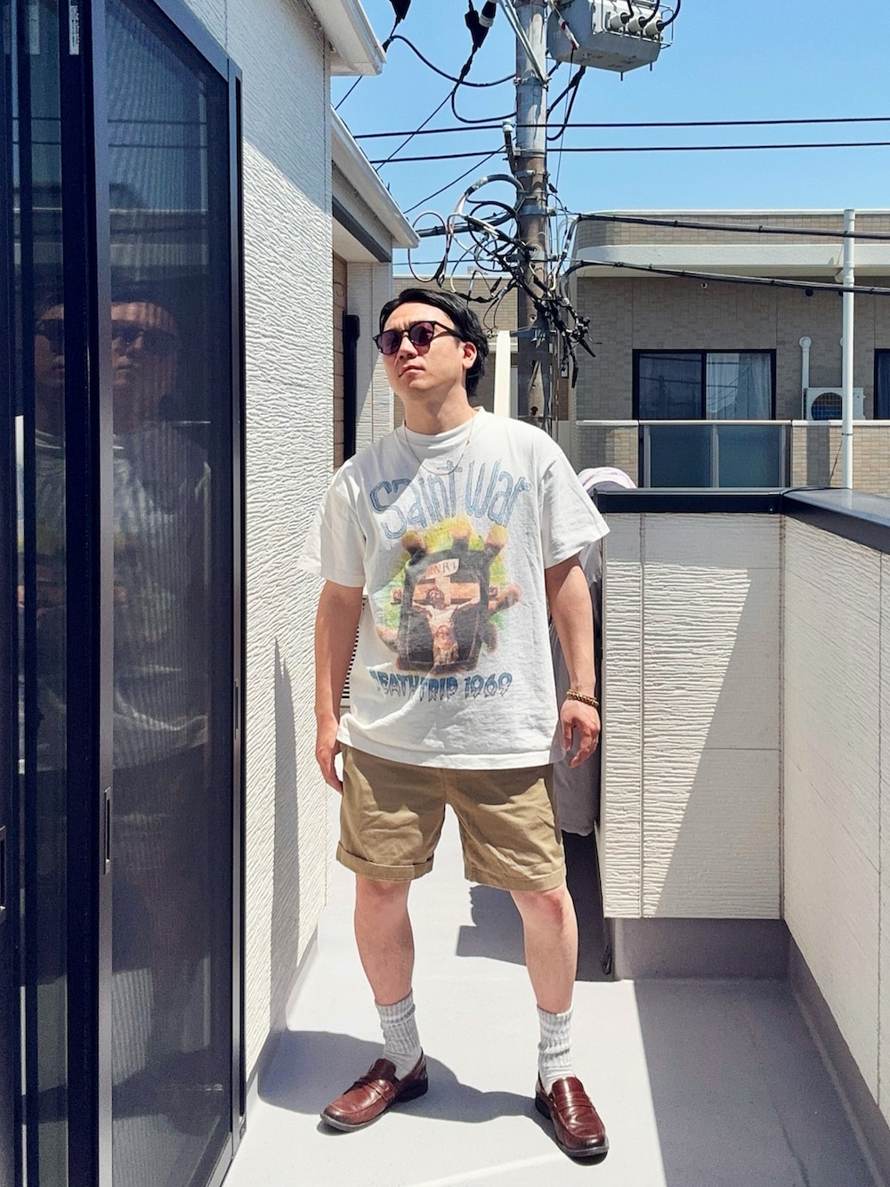ホワイト系のTシャツ/カットソー、ベージュ系のパンツ、ブラウン系のローファーを着用したメンズの春コーディネートの3枚目の写真