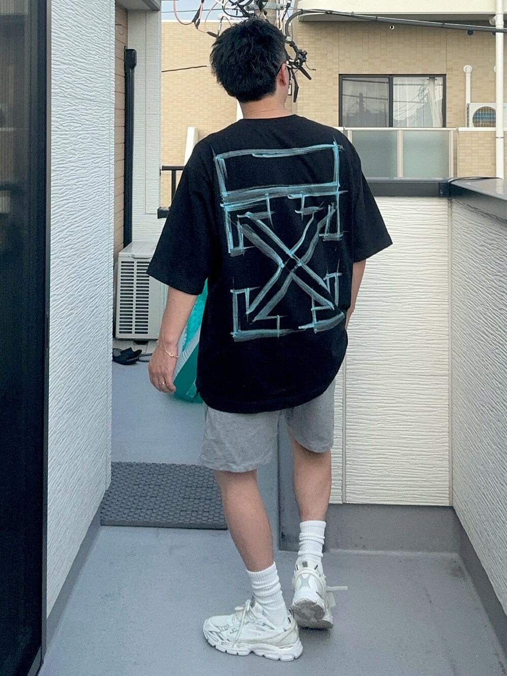 ブラック系のTシャツ/カットソー、グレー系のパンツ、ホワイト系のスニーカーを着用したメンズの夏コーディネートの3枚目の写真