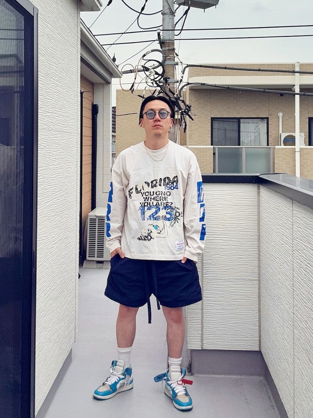 ホワイト系のTシャツ/カットソー、ブルー系のパンツ、ブルー系のスニーカーを着用したメンズの夏コーディネートの3枚目の写真