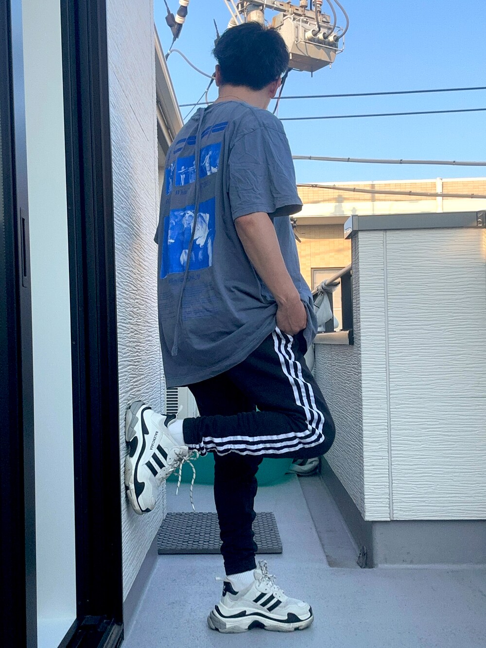 ブラック系のスウェットパンツ、ブルー系のTシャツ/カットソー、ホワイト系のシューズを着用したメンズの夏コーディネートの3枚目の写真