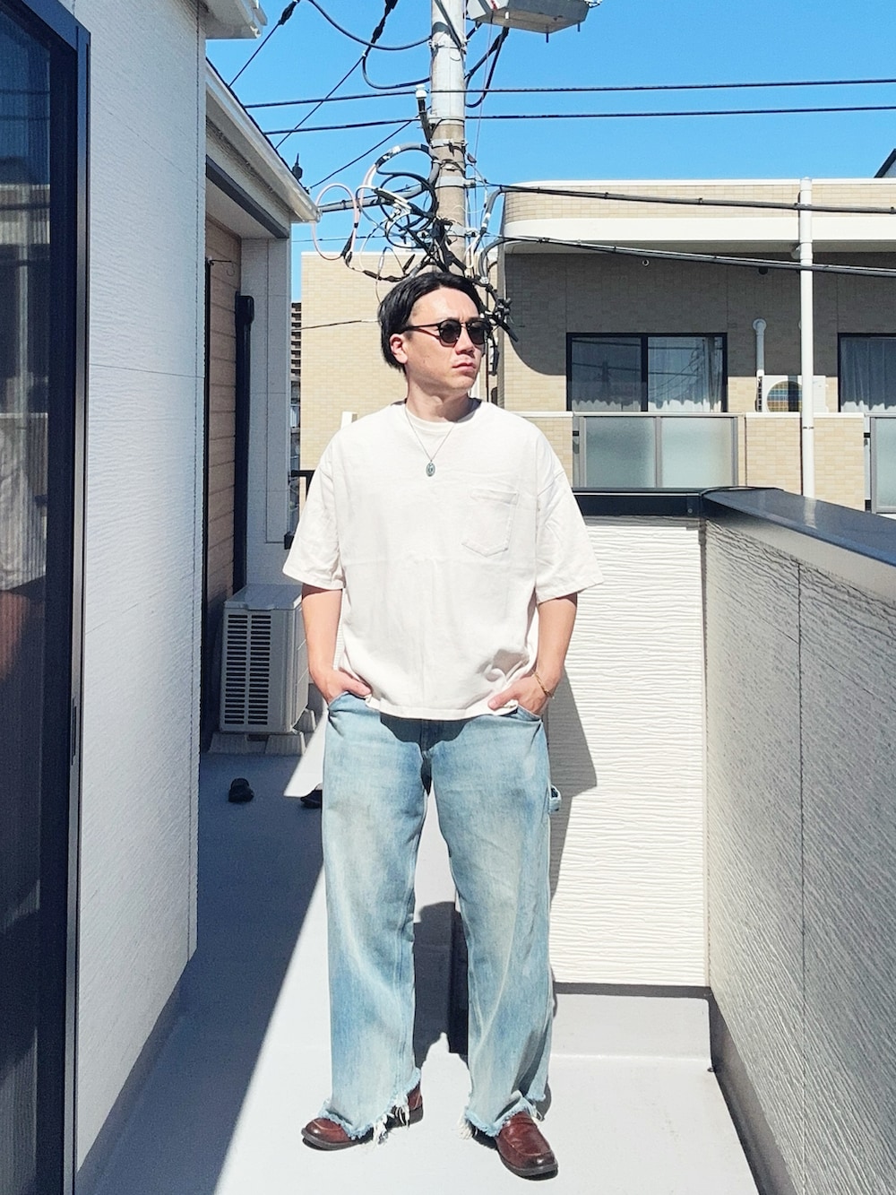 ブルー系のデニムパンツ、ホワイト系のTシャツ/カットソー、ブラウン系のローファーを着用したメンズの夏コーディネートの2枚目の写真