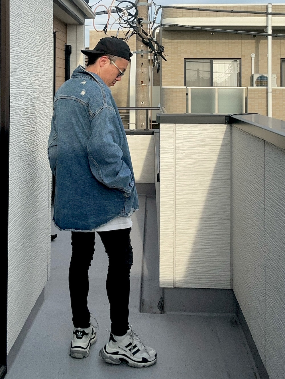 ホワイト系のTシャツ/カットソー、ブルー系のデニムジャケット、ブラック系のデニムパンツを着用したメンズの秋コーディネートの4枚目の写真