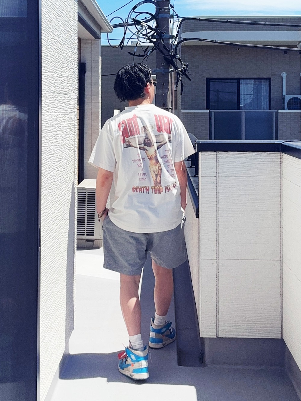 ホワイト系のTシャツ/カットソー、グレー系のパンツ、ブルー系のスニーカーを着用したメンズの春コーディネートの4枚目の写真