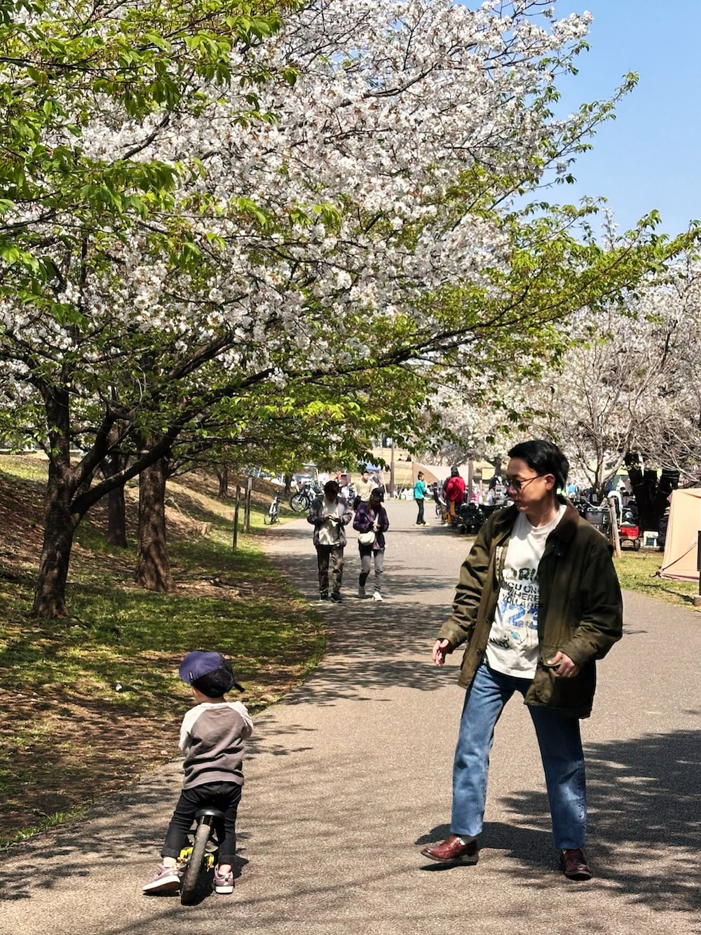 ブルー系のデニムパンツ、ホワイト系のTシャツ/カットソー、グリーン系のジャケット/アウターを着用したメンズの春コーディネートの3枚目の写真