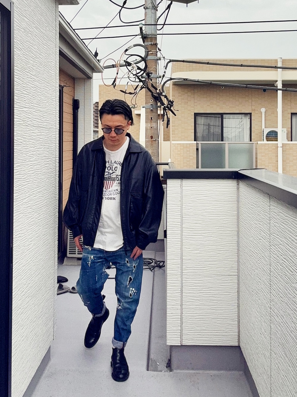 ブラック系のブルゾン、ブルー系のデニムパンツ、ホワイト系のTシャツ/カットソーを着用したメンズの春コーディネートの2枚目の写真