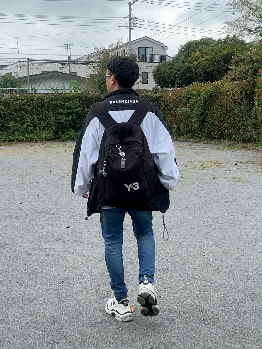 ブルー系のデニムパンツ、グレー系のTシャツ/カットソー、ブラック系のバックパック/リュックを着用したメンズの秋コーディネートの3枚目の写真