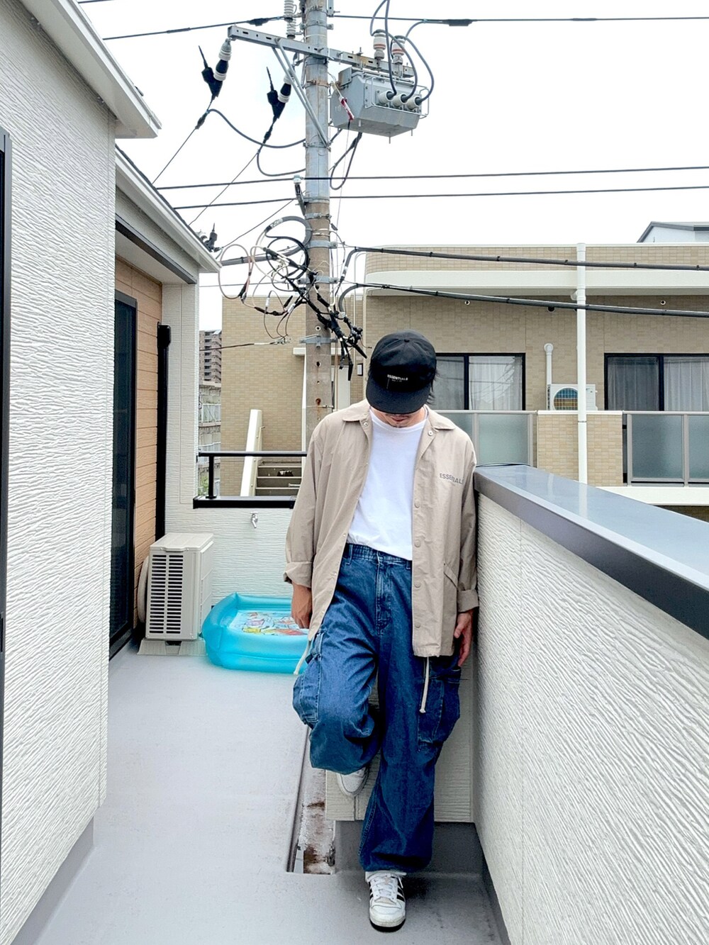 ホワイト系のTシャツ/カットソー、ベージュ系のブルゾン、ブルー系のカーゴパンツを着用したメンズの秋コーディネートの3枚目の写真