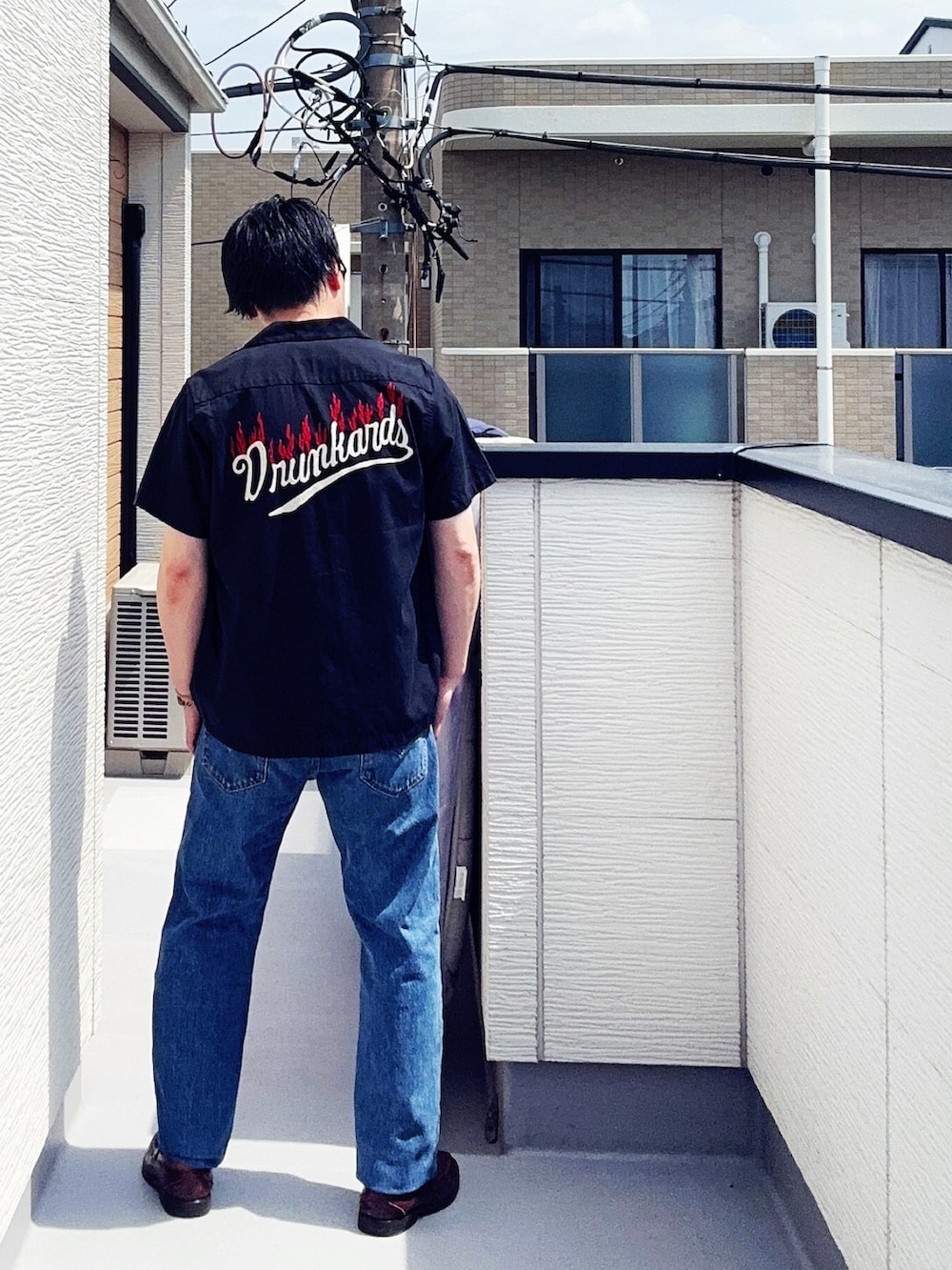 ブルー系のデニムパンツ、ホワイト系のタンクトップ、ブラック系のシャツ/ブラウスを着用したメンズの春コーディネートの3枚目の写真
