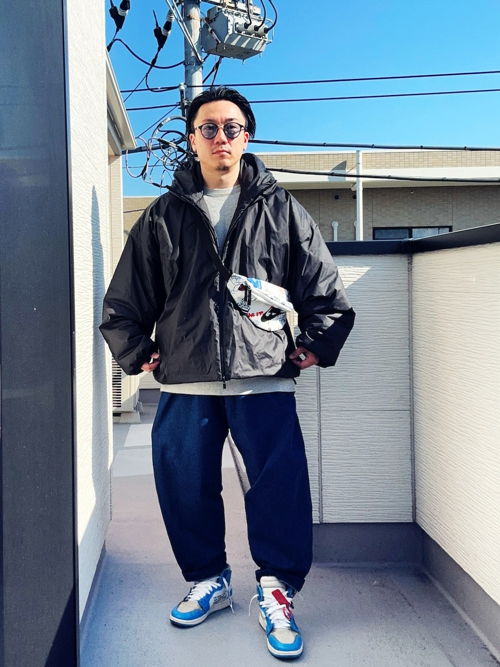 ブルー系のデニムパンツ、グレー系のスウェット、ブラック系のジャケット/アウターを着用したメンズの冬コーディネートの2枚目の写真