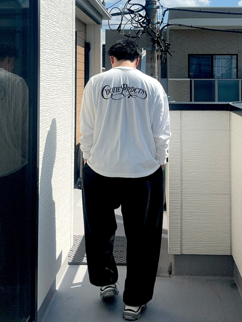 ブラック系のスウェットパンツ、ホワイト系のTシャツ/カットソー、ホワイト系のシューズを着用したメンズの秋コーディネートの4枚目の写真