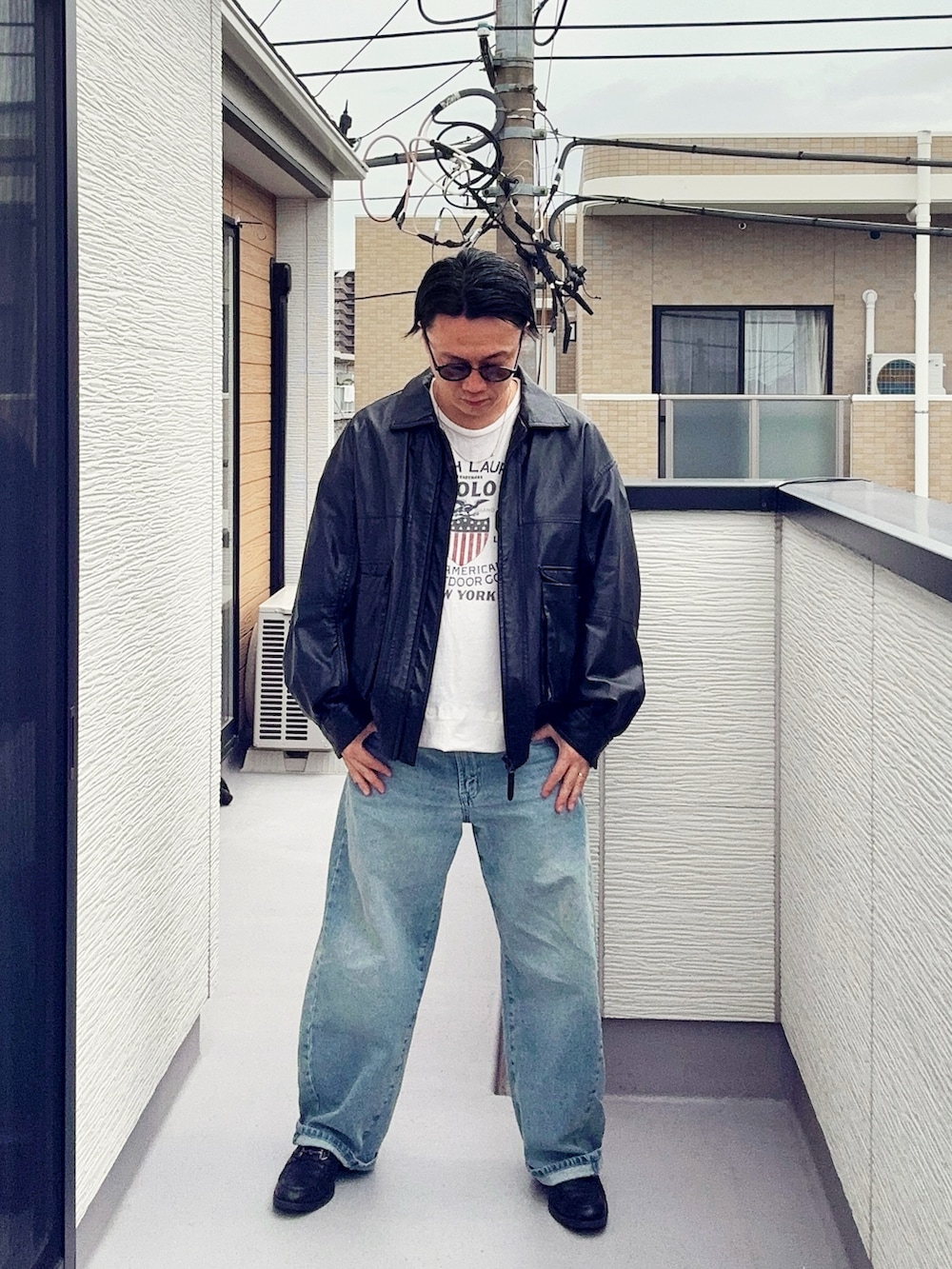 ブラック系のブルゾン、ブラック系のローファー、ホワイト系のTシャツ/カットソーを着用したメンズの春コーディネートの3枚目の写真