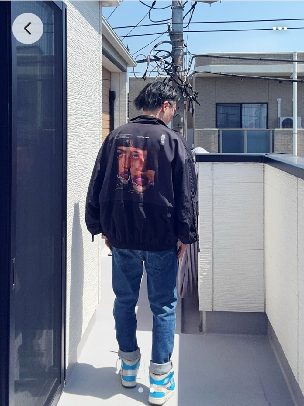 ブルー系のデニムパンツ、ホワイト系のTシャツ/カットソー、ブラック系のジャケット/アウターを着用したメンズの春コーディネートの2枚目の写真