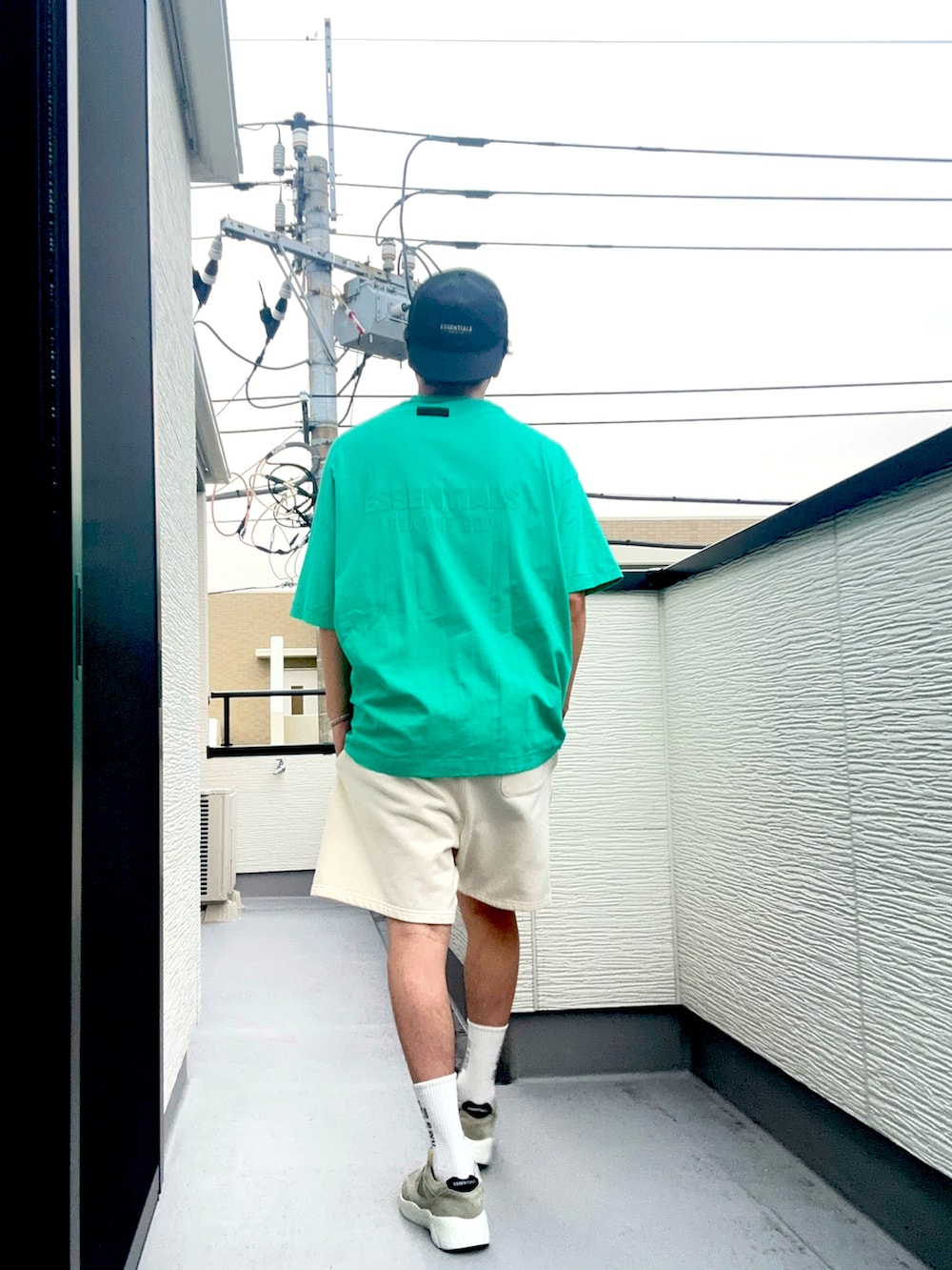 ホワイト系のスウェットパンツ、グレー系のスニーカー、グリーン系のTシャツ/カットソーを着用したメンズの夏コーディネートの3枚目の写真