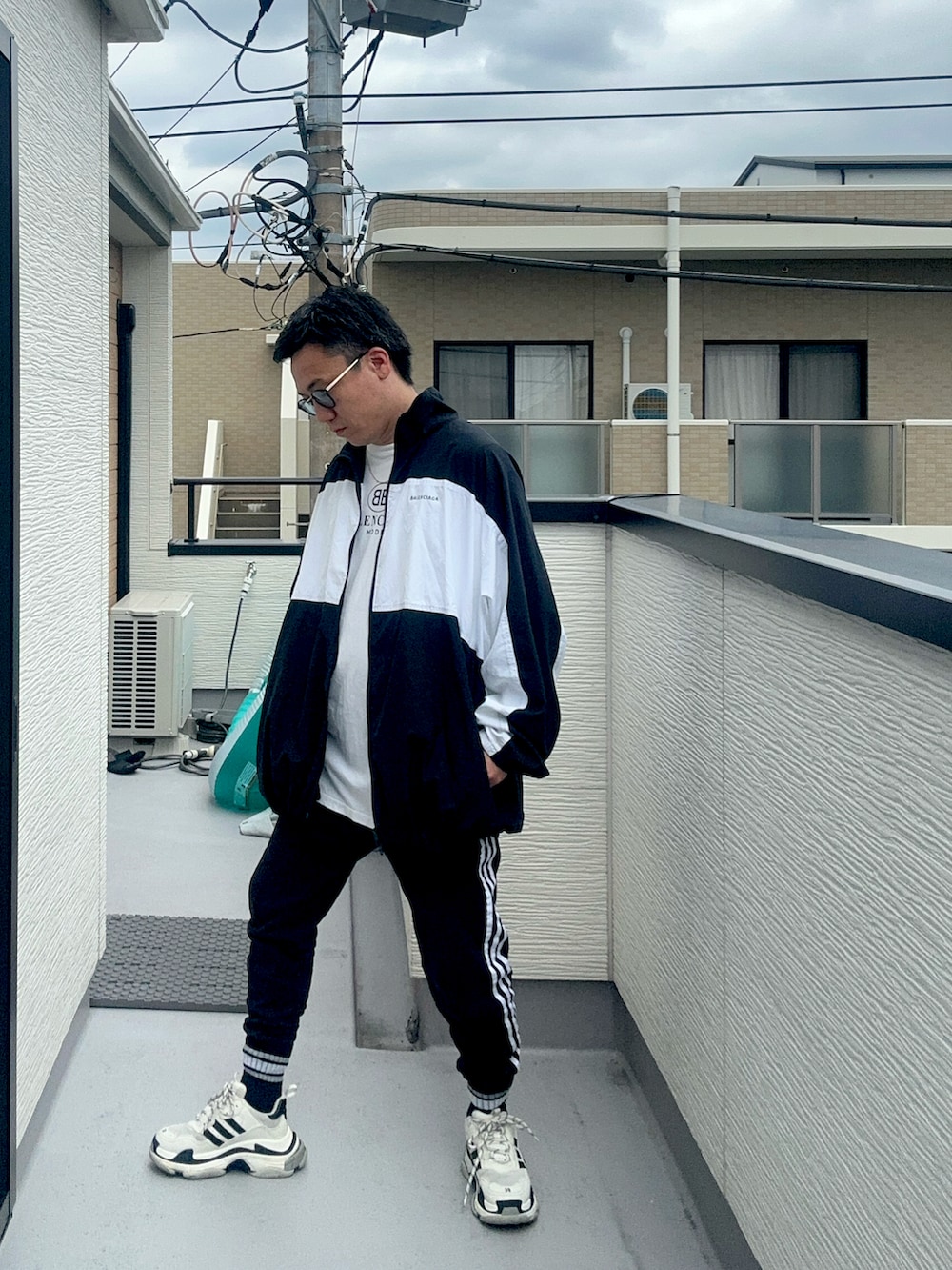 ブラック系のスウェットパンツ、ホワイト系のTシャツ/カットソー、ブラック系のナイロンジャケットを着用したメンズの秋コーディネートの3枚目の写真