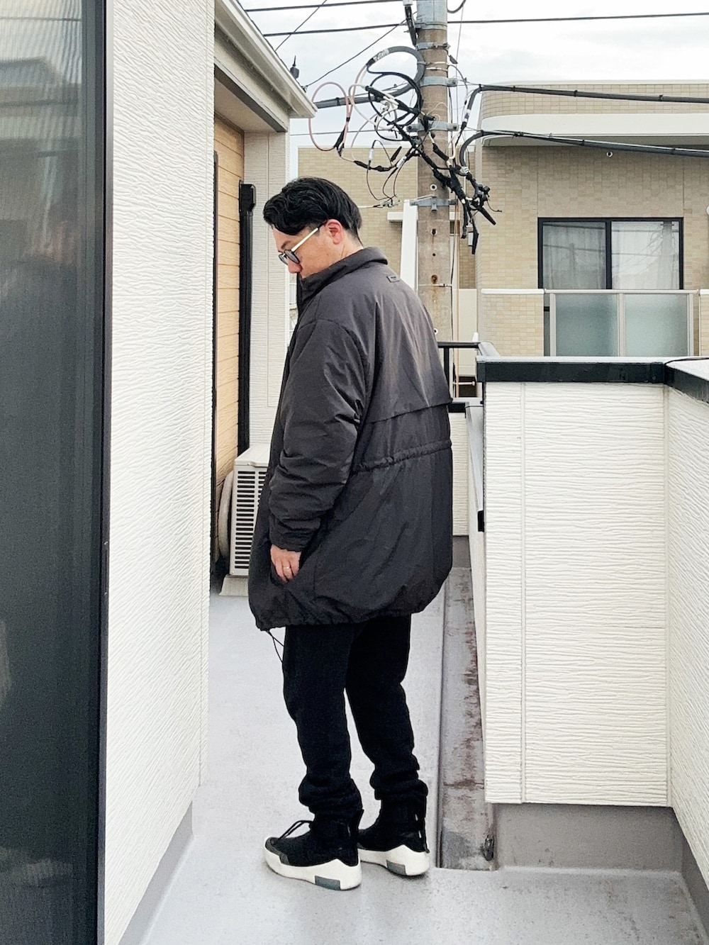 ベージュ系のスウェット、ブラック系のその他アウター、ブラック系のスウェットパンツを着用したメンズの秋コーディネートの3枚目の写真