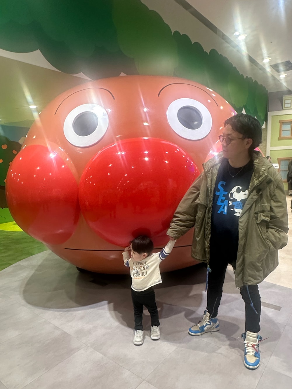 ブルー系のスウェット、ベージュ系のTシャツ/カットソー、グリーン系のミリタリージャケットを着用したメンズの冬コーディネートの4枚目の写真