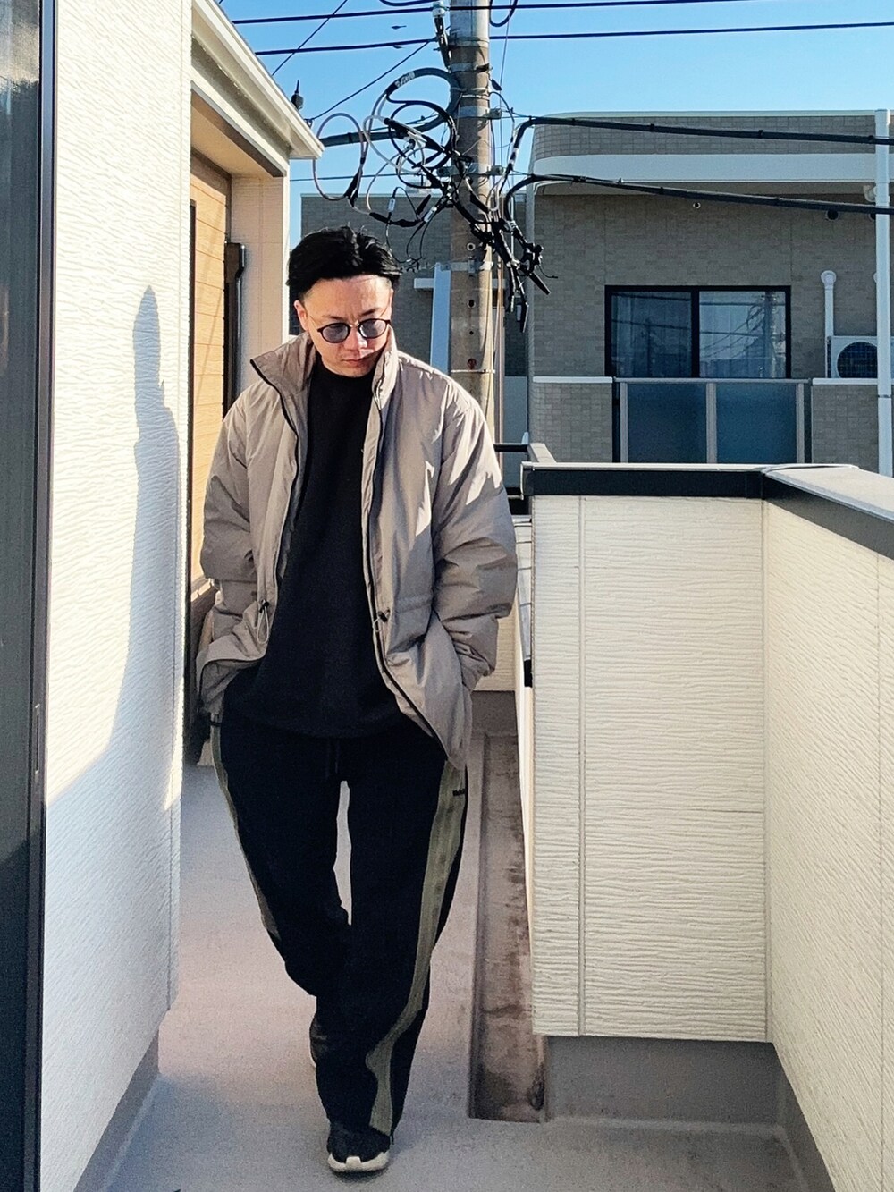 ブラック系のスウェット、ベージュ系のその他アウター、ブラック系のパンツを着用したメンズの冬コーディネートの4枚目の写真