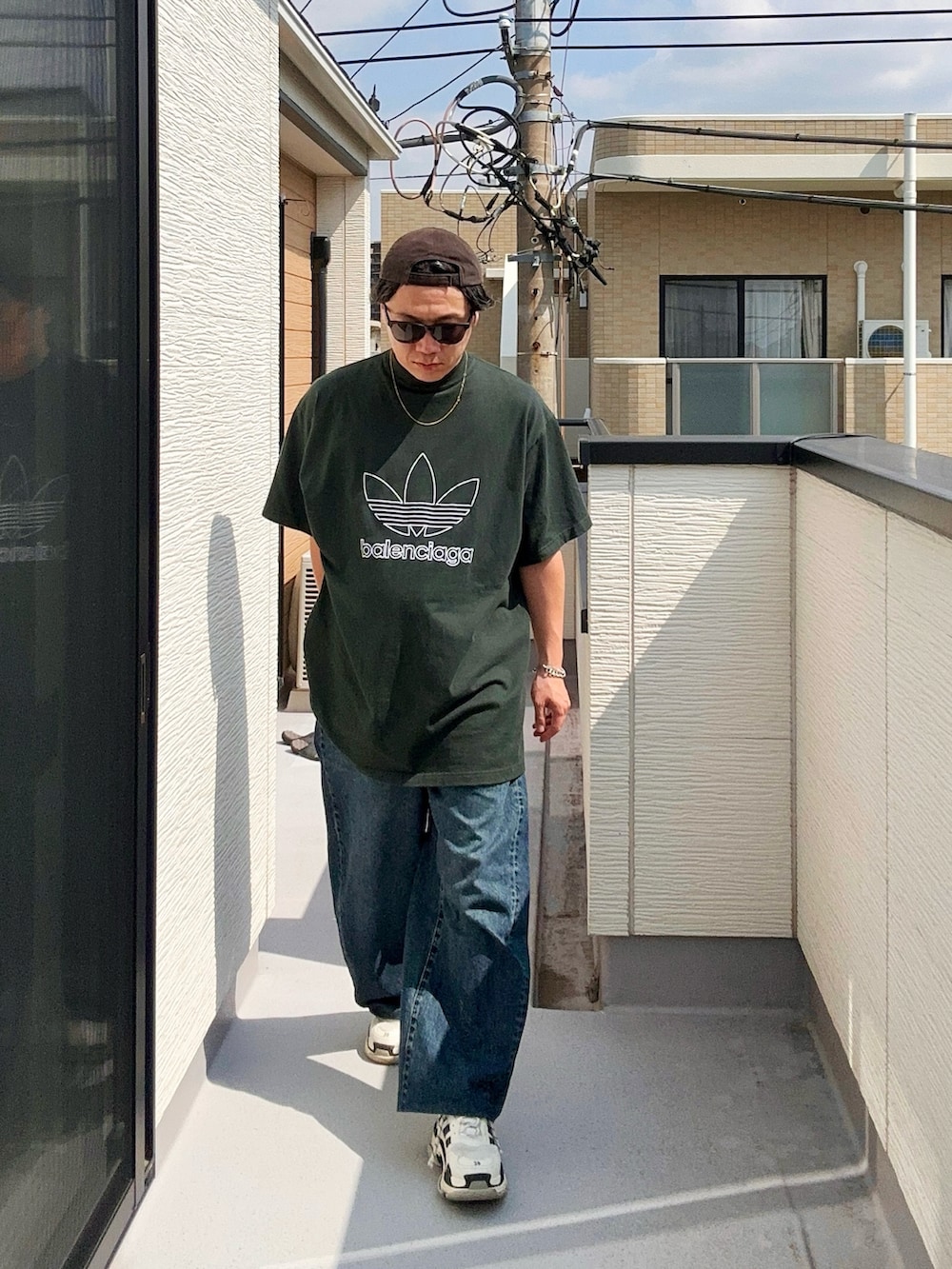 グリーン系のTシャツ/カットソー、ブルー系のデニムパンツ、ホワイト系のシューズを着用したメンズの秋コーディネートの3枚目の写真