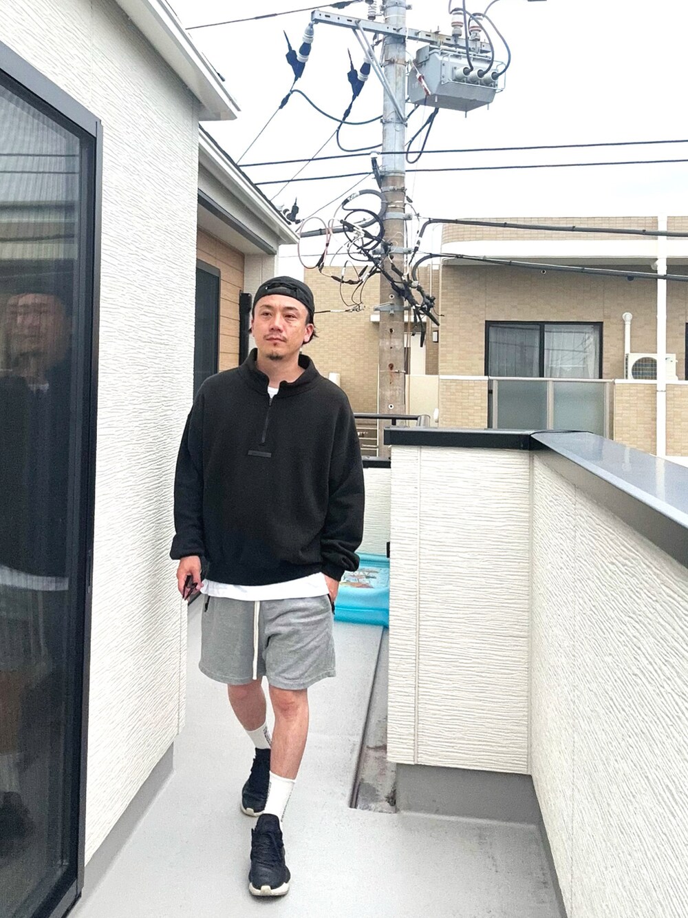 ブラック系のスウェット、グレー系のパンツ、ブラック系のスニーカーを着用したメンズの秋コーディネートの2枚目の写真