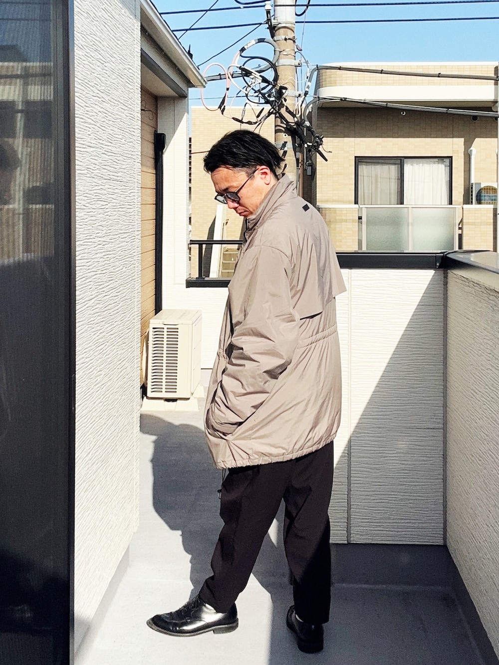 ベージュ系のその他アウター、ブラック系のスラックス、ホワイト系のシャツ/ブラウスを着用したメンズの春コーディネートの4枚目の写真