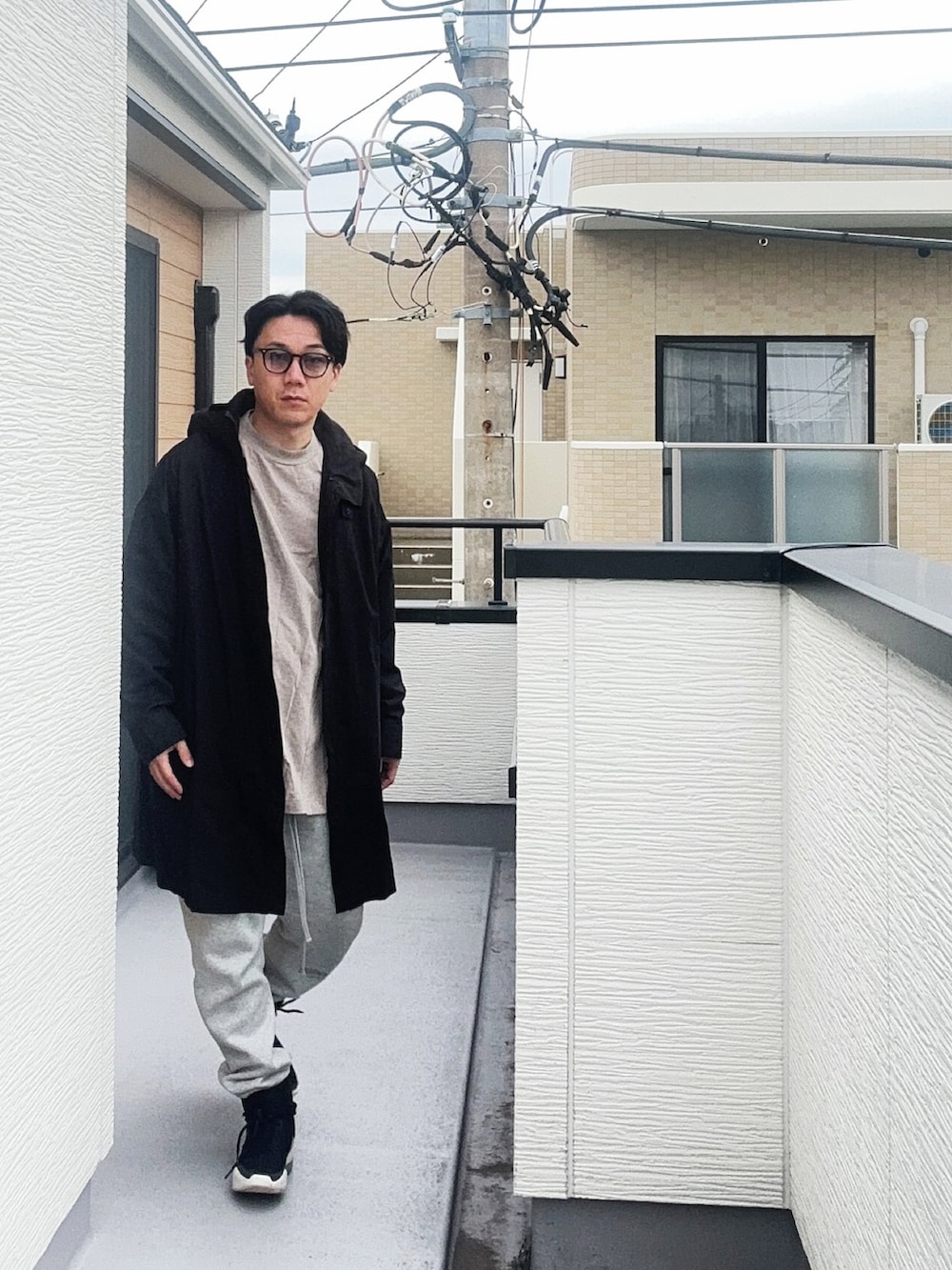 ブラック系のその他アウター、グレー系のTシャツ/カットソー、グレー系のスウェットパンツを着用したメンズの秋コーディネートの2枚目の写真