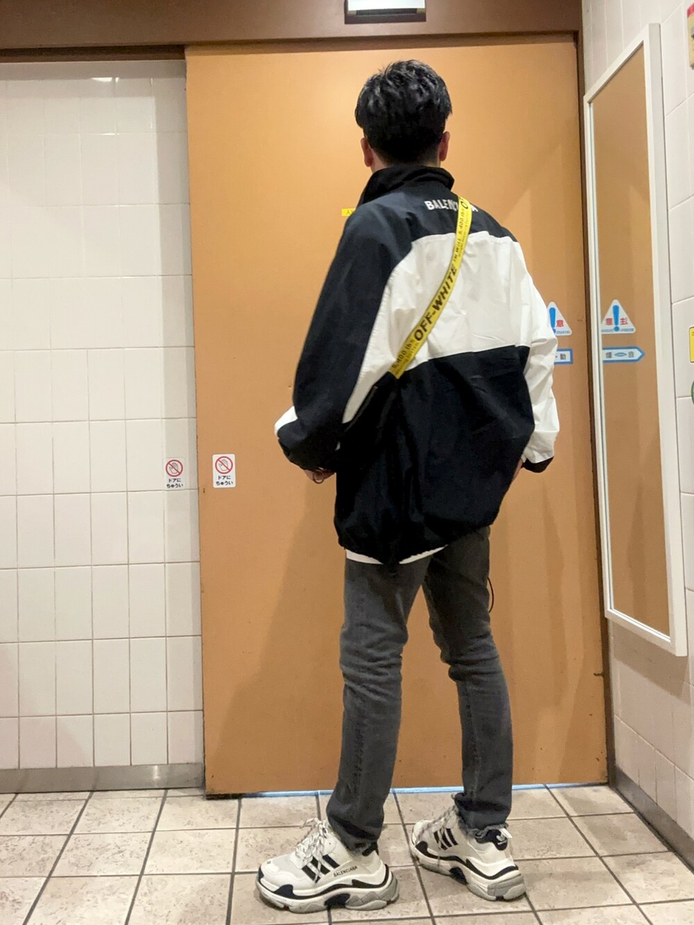 グレー系のデニムパンツ、ブラック系のショルダーバッグ、ブラック系のスニーカーを着用したメンズの秋コーディネートの4枚目の写真