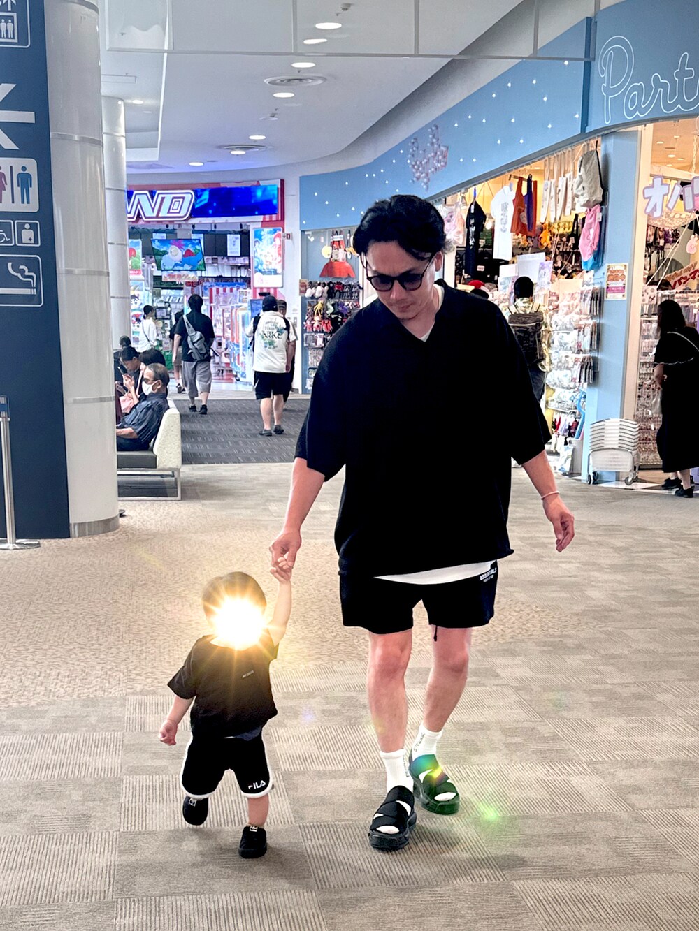 ブラック系のポロシャツ、ブラック系のスウェットパンツ、ブラック系のサンダルを着用したメンズの夏コーディネートの2枚目の写真