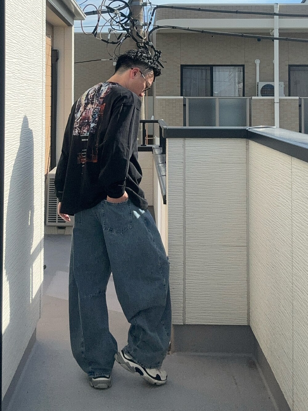 ブルー系のデニムパンツ、ブラック系のTシャツ/カットソー、ホワイト系のシューズを着用したメンズの秋コーディネートの3枚目の写真