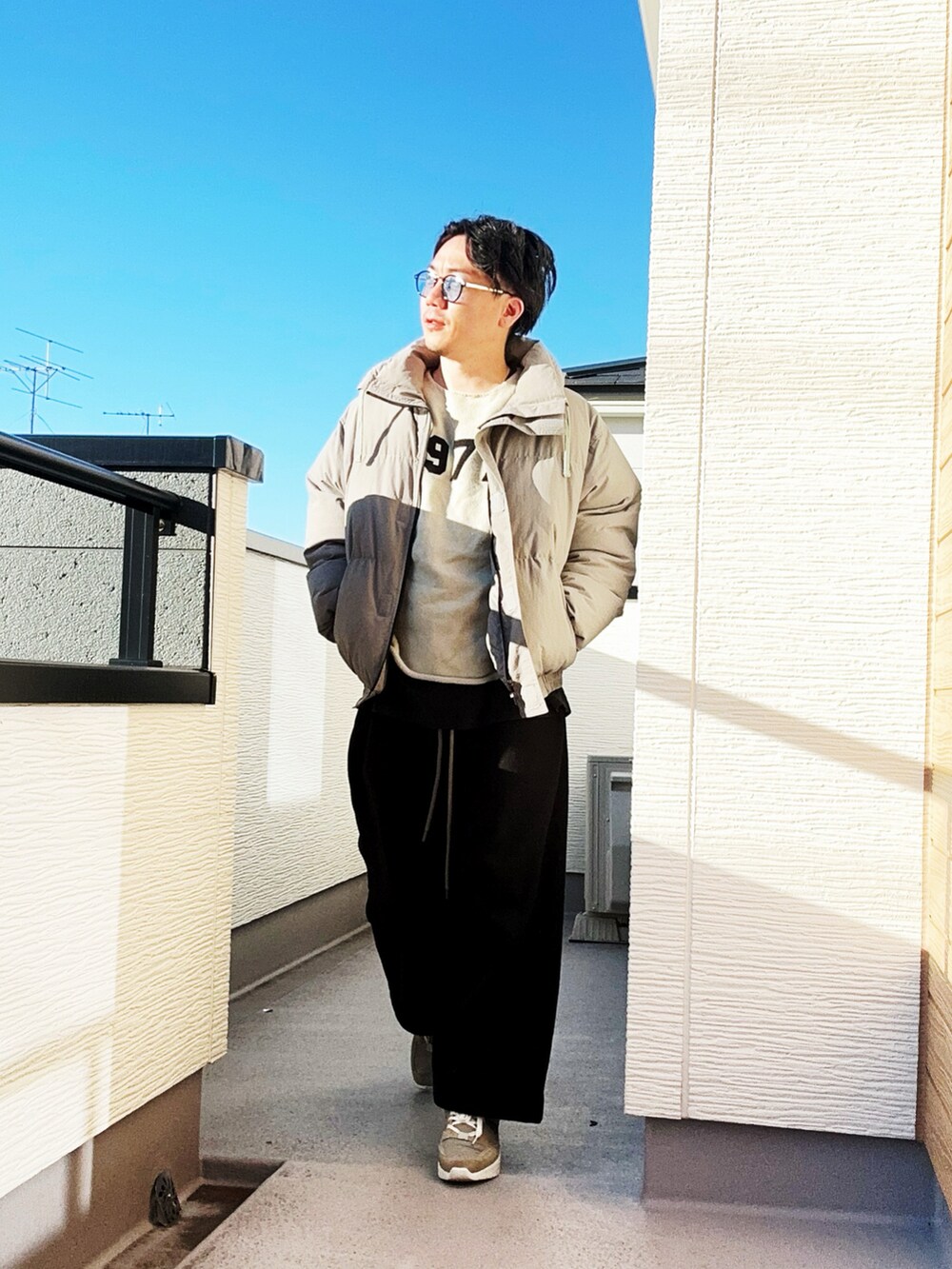 ホワイト系のニット/セーター、グレー系のダウンジャケット/コート、ブラック系のスウェットパンツを着用したメンズの冬コーディネートの3枚目の写真