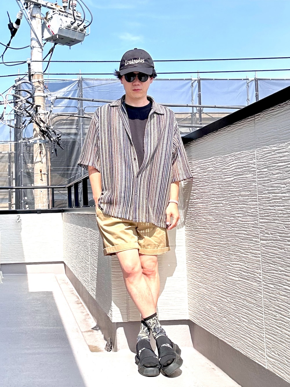 ブラウン系のシャツ/ブラウス、ベージュ系のパンツ、ブラック系のTシャツ/カットソーを着用したメンズの夏コーディネートの4枚目の写真