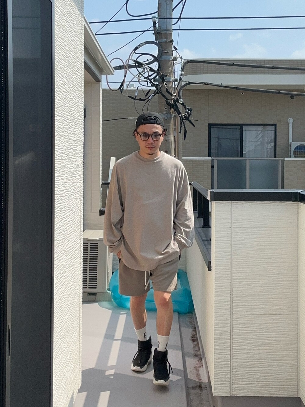 グレー系のTシャツ/カットソー、グレー系のスウェットパンツ、ブラック系のスニーカーを着用したメンズの秋コーディネートの2枚目の写真