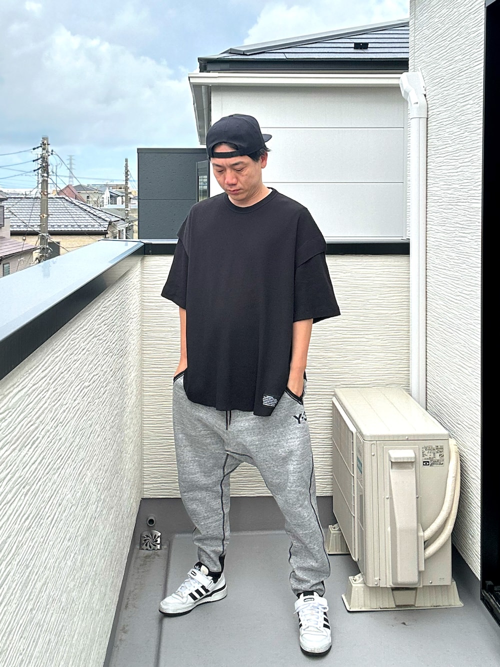 ブラック系のその他トップス、グレー系のパンツ、ホワイト系のスニーカーを着用したメンズの夏コーディネートの2枚目の写真