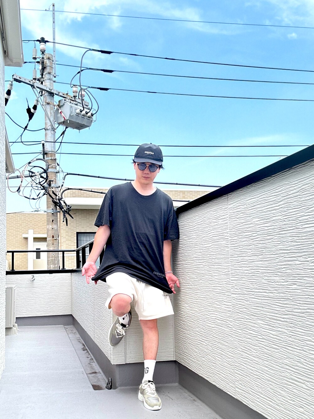 グレー系のスニーカー、ブラック系のTシャツ/カットソー、ホワイト系のスウェットパンツを着用したメンズの夏コーディネートの3枚目の写真