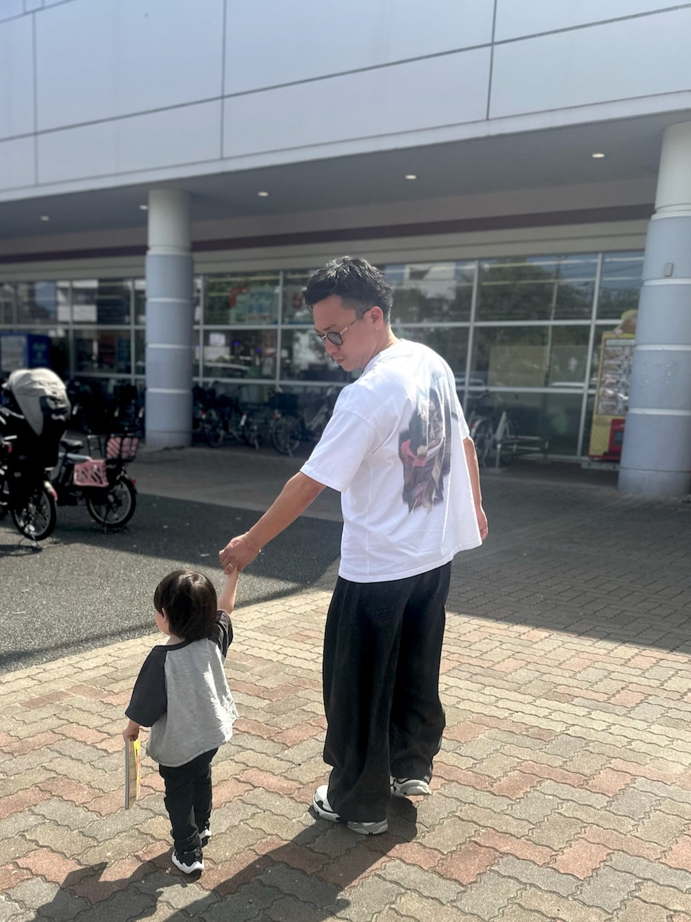 ブラック系のデニムパンツ、ブラック系のスニーカー、ホワイト系のTシャツ/カットソーを着用したメンズの秋コーディネートの3枚目の写真