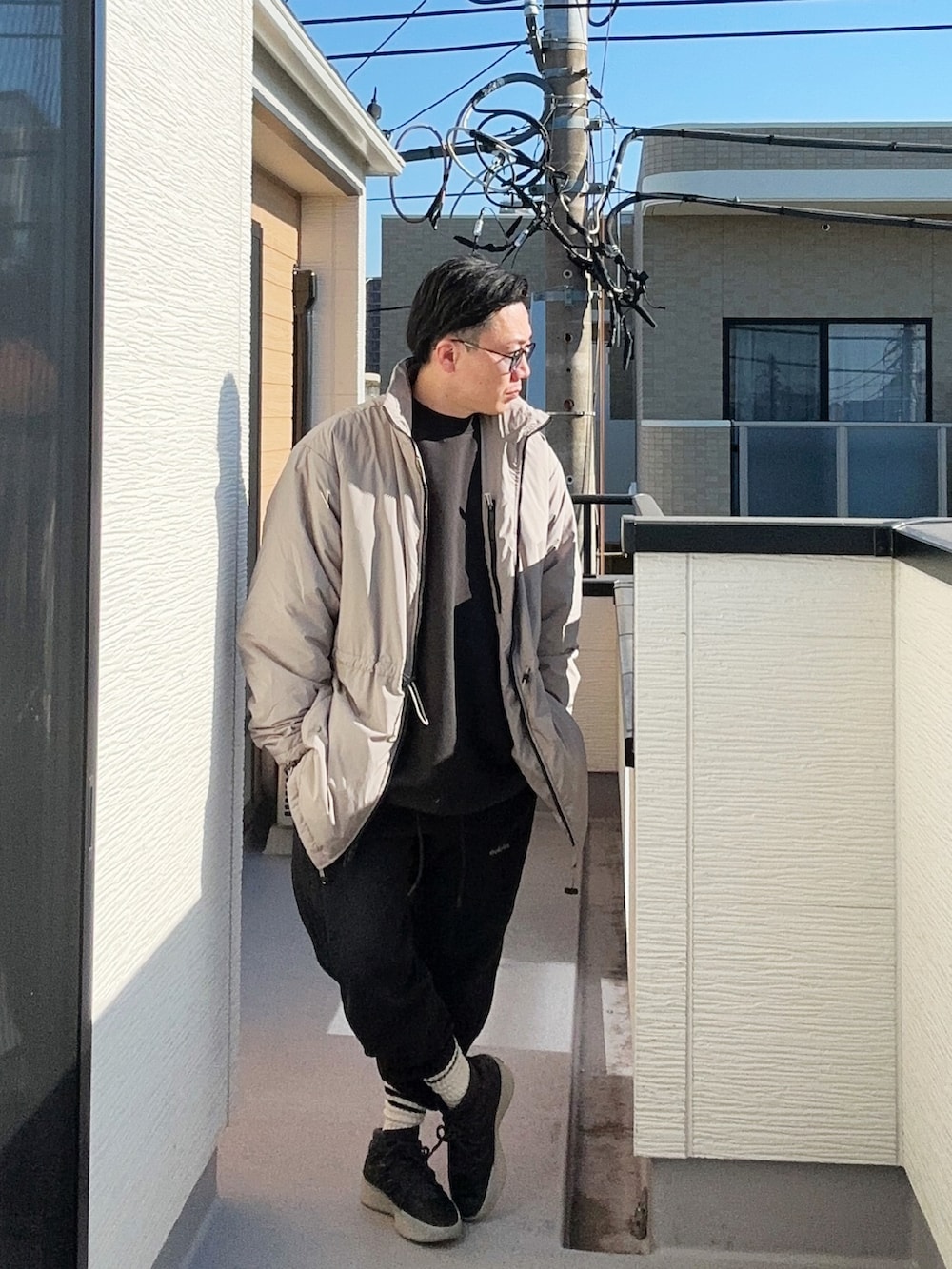 ブラック系のスニーカー、ブラック系のスウェットパンツ、ブラック系のスウェットを着用したメンズの冬コーディネートの4枚目の写真