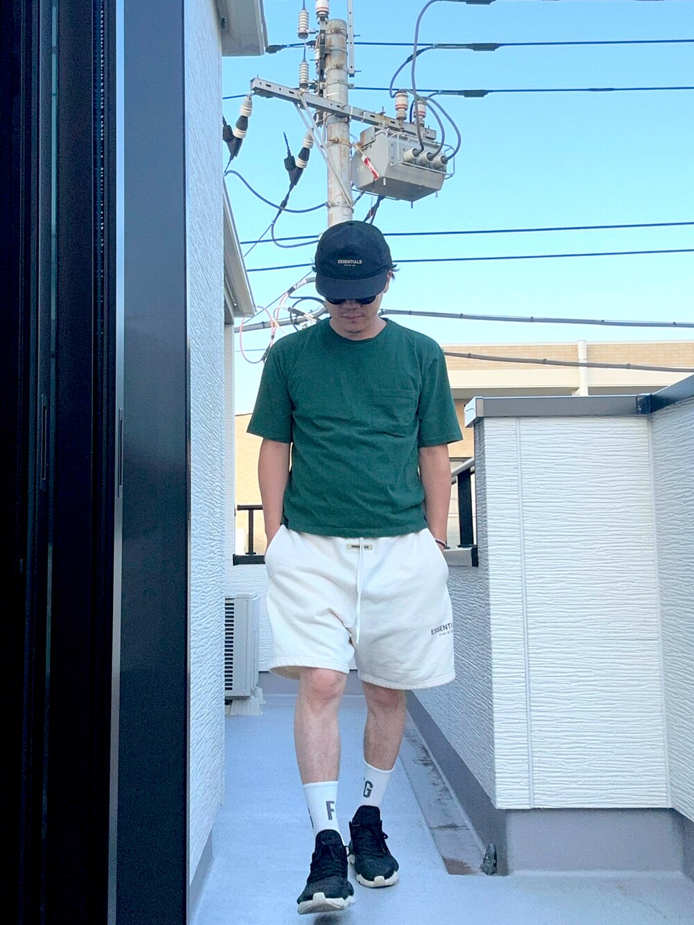 グリーン系のTシャツ/カットソー、ホワイト系のスウェットパンツ、ブラック系のスニーカーを着用したメンズの夏コーディネートの2枚目の写真