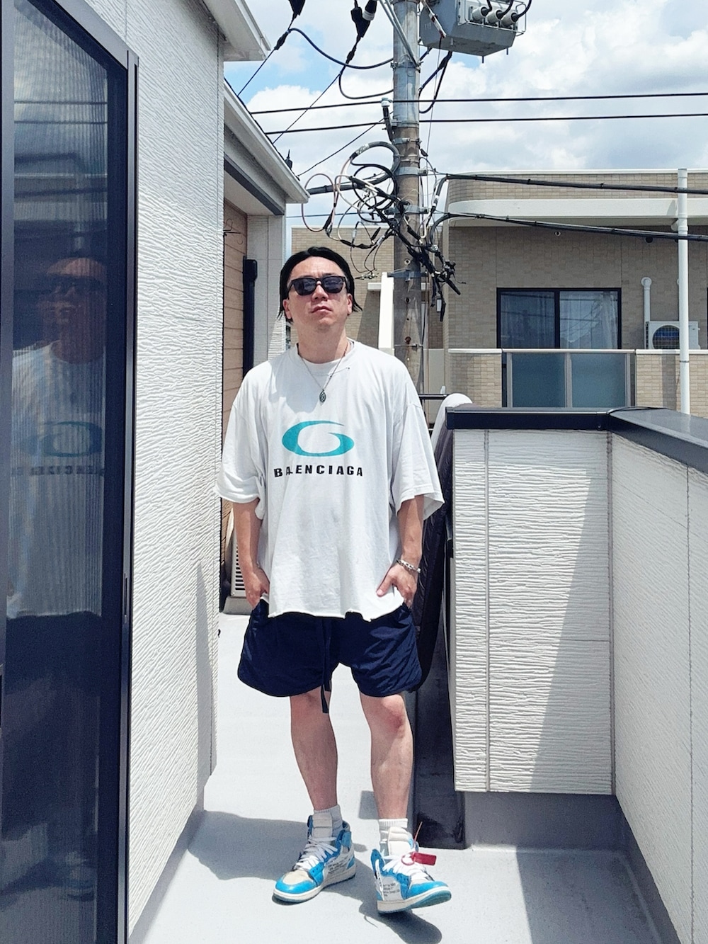 ホワイト系のTシャツ/カットソー、ブルー系のパンツ、ブルー系のスニーカーを着用したメンズの夏コーディネートの3枚目の写真