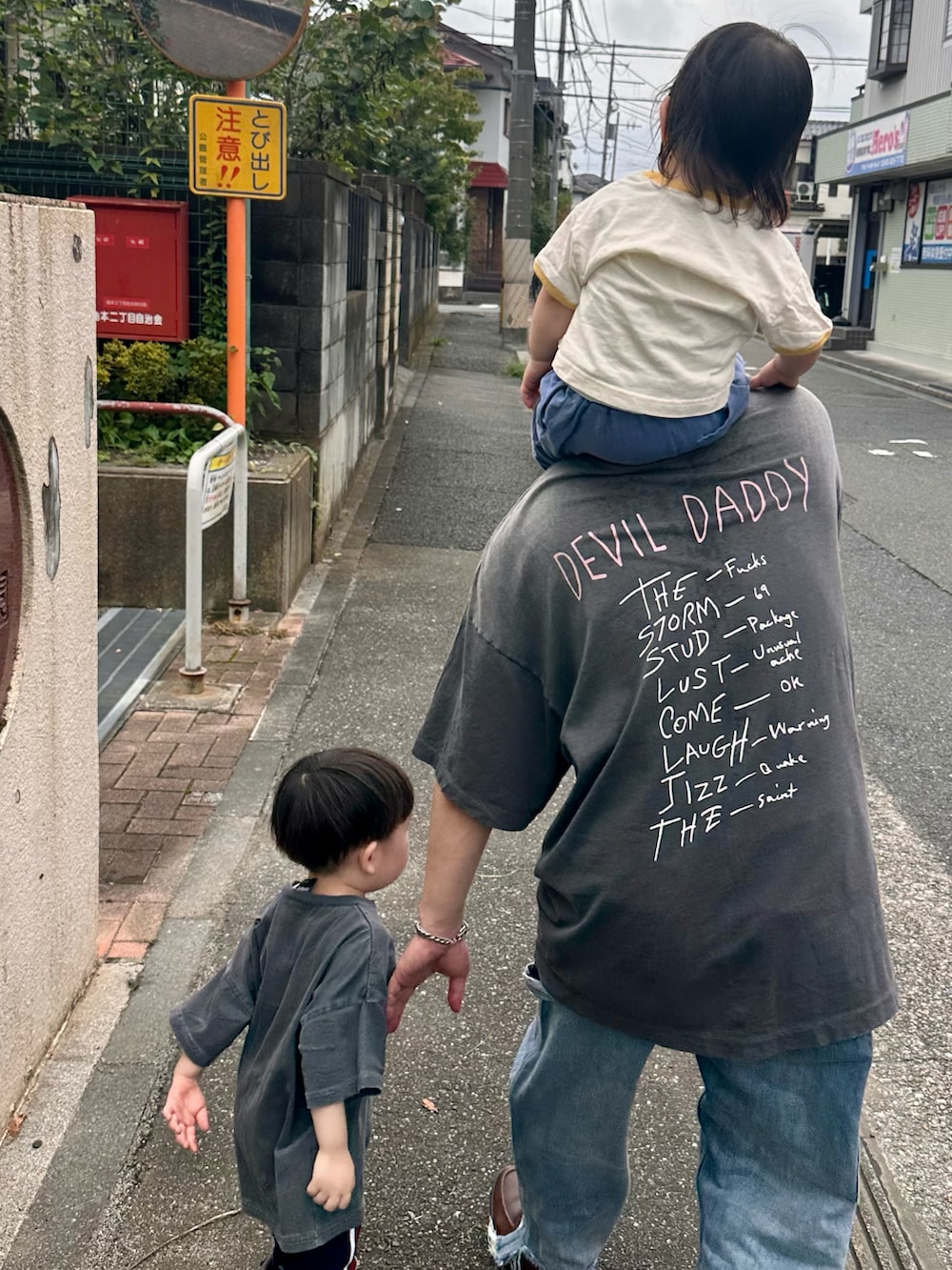 ブルー系のデニムパンツ、ブラック系のTシャツ/カットソー、ブラウン系のローファーを着用したメンズの秋コーディネートの3枚目の写真
