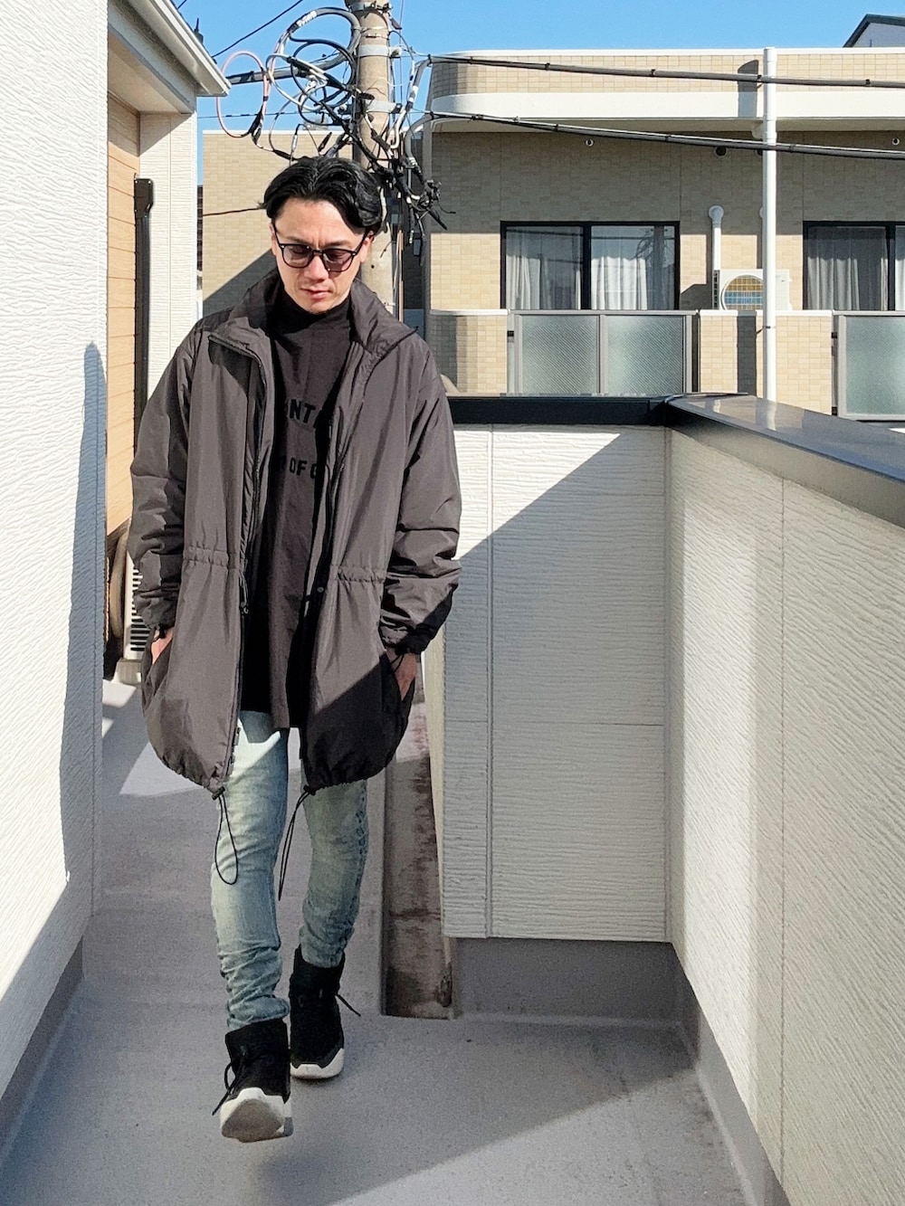 ブラック系のTシャツ/カットソー、ブラック系のその他アウター、ブルー系のデニムパンツを着用したメンズの秋コーディネートの2枚目の写真