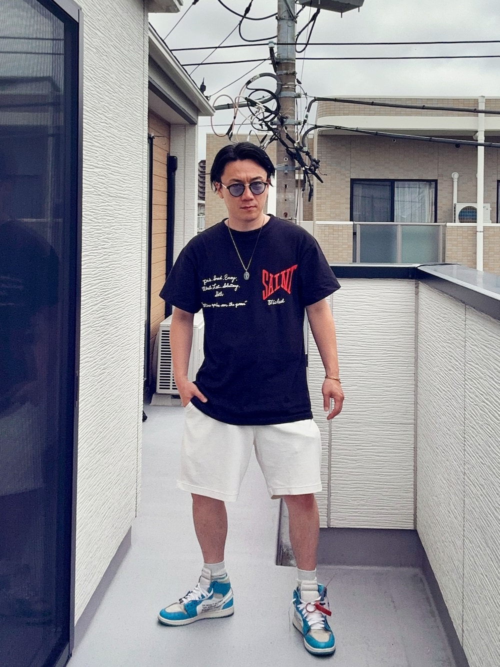 ブラック系のTシャツ/カットソー、ホワイト系のパンツ、ブルー系のスニーカーを着用したメンズの夏コーディネートの2枚目の写真